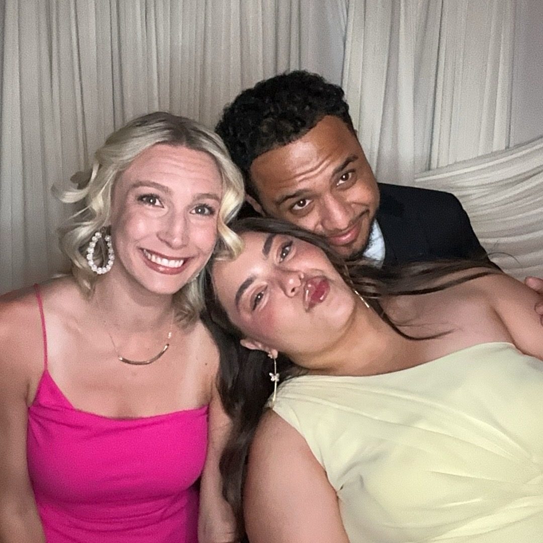 Three guests laughing and leaning into the frame together